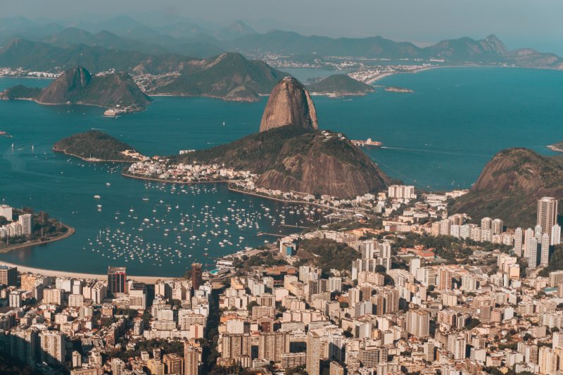 An aerial photo of Rio de Janeiro surrounded by the sea and hills under the sunlight in Brazil