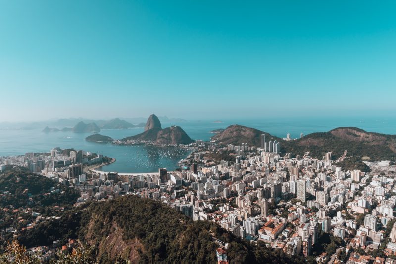 A landscape of Rio De Janeiro surrounded by the sea under a blue sky in Brazil