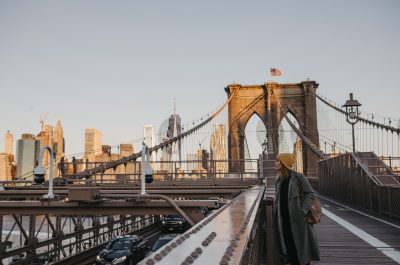 USA, New York, New York City, female tourist on Brooklyn Bridge in the morning light