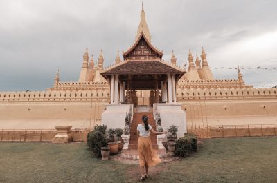 Woman walking towards pha that luang vientiane in laos